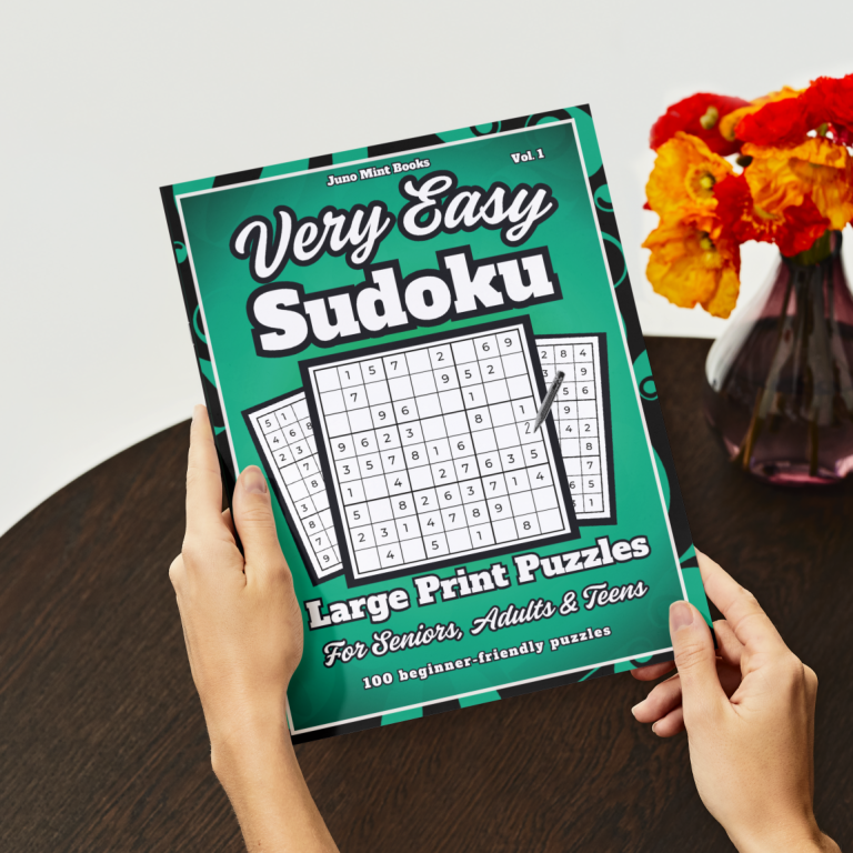 Very Easy Sudoku Large Print Puzzle Book Person holding a Very Easy Sudoku Large Print Puzzle Book while sitting at a table.